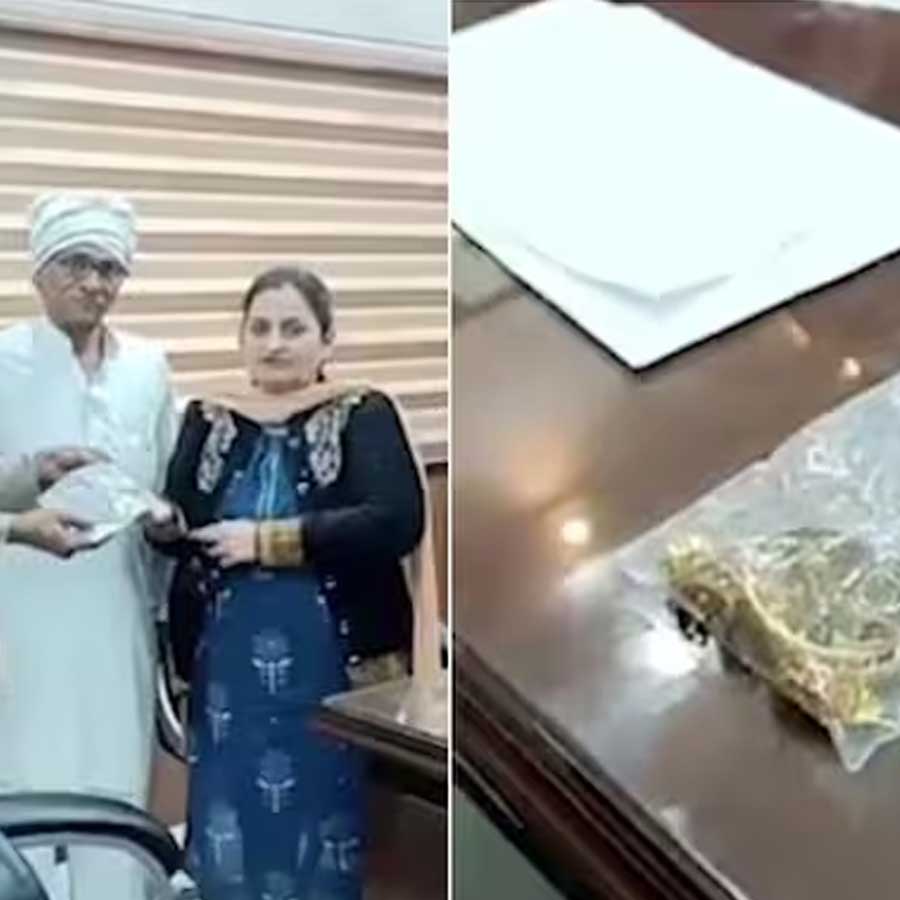 শর্মা দম্পতির (ডান দিকে) হাতে সেই গয়না তুলে দিচ্ছেন ক্রেতা হাজি আখতার খান (বাঁ দিকে নীল জ্যাকেট পরা)। ছবি: সংগৃহীত।