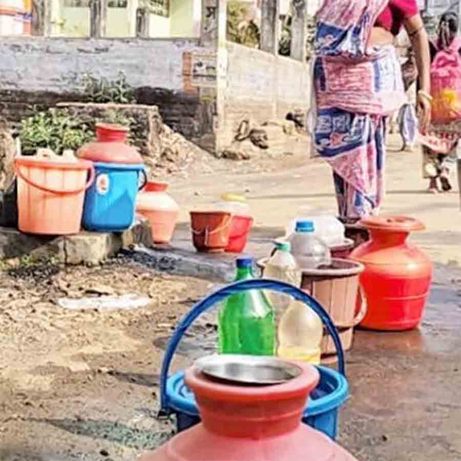 খাতড়া বাজার এলাকায় জলের পাত্র রেখে লাইন দেন বাসিন্দারা।