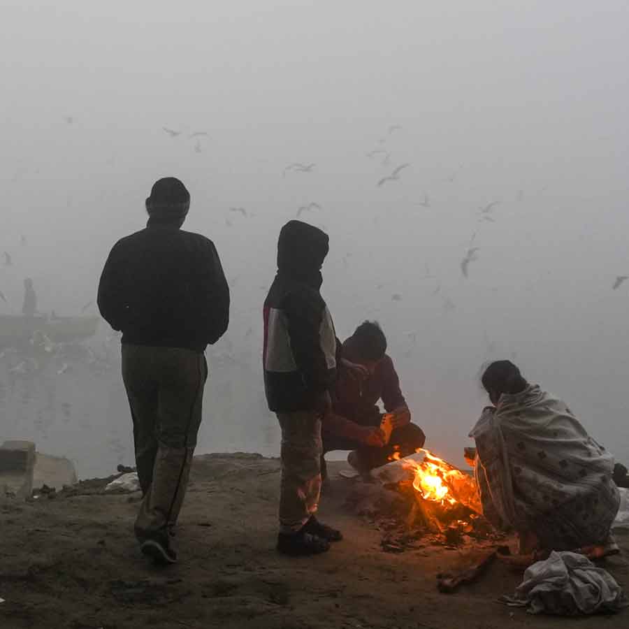 ঠান্ডায় কাঁপছে দিল্লি। উষ্ণতা পেতে আগুন পোহানো চলছে। ছবি: পিটিআই।
