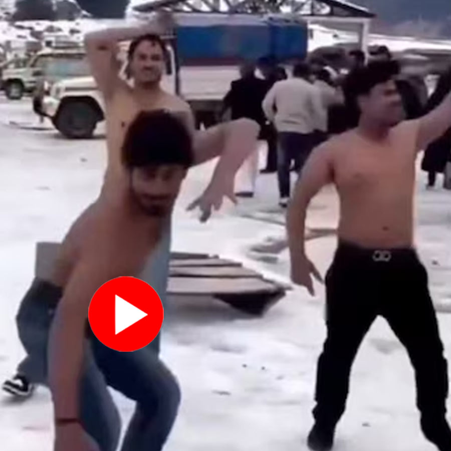 several youths can be seen dancing on a road in Sonmarg’s