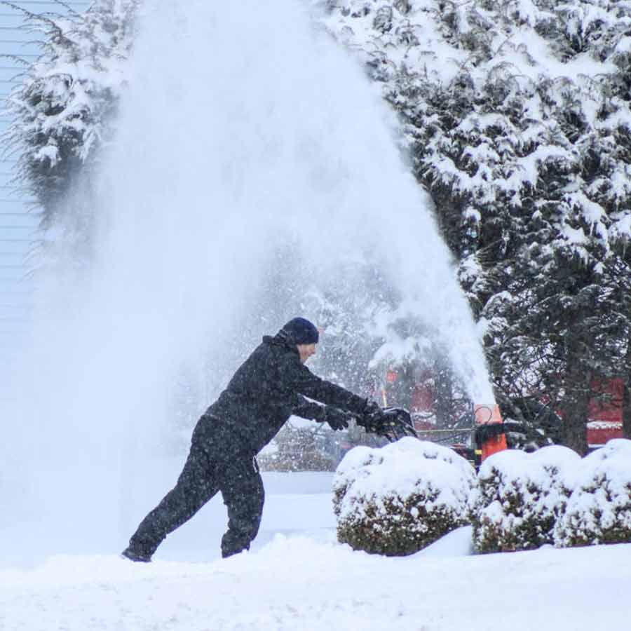 নিউ জার্সির নরউডে বাড়ির সামনের রাস্তা থেকে বরফ সরাচ্ছেন এক বাসিন্দা।