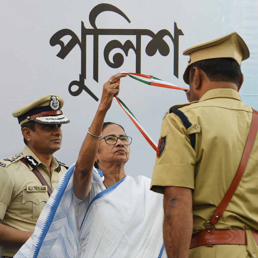 পুলিশ আধিকারিককে পদক পরাচ্ছেন মুখ্যমন্ত্রী মমতা বন্দ্যোপাধ্যায়। পিছনে রাজ্য পুলিশের বর্তমান ডিজি রাজীব কুমার।