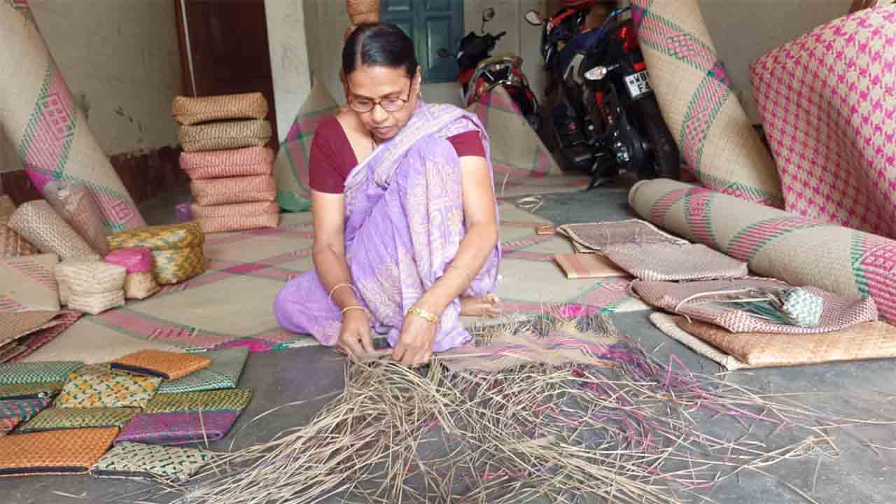 শীতলপাটি বুনছেন এক শিল্পী।