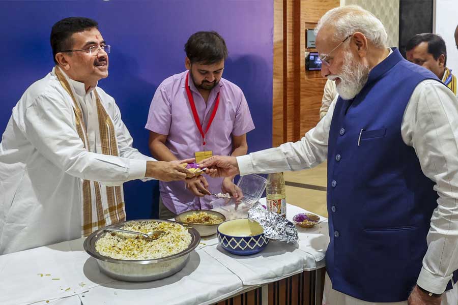 নরেন্দ্র মোদীর হাতে ঝালমুড়ির বাটি তুলে দিচ্ছেন শুভেন্দু অধিকারী।