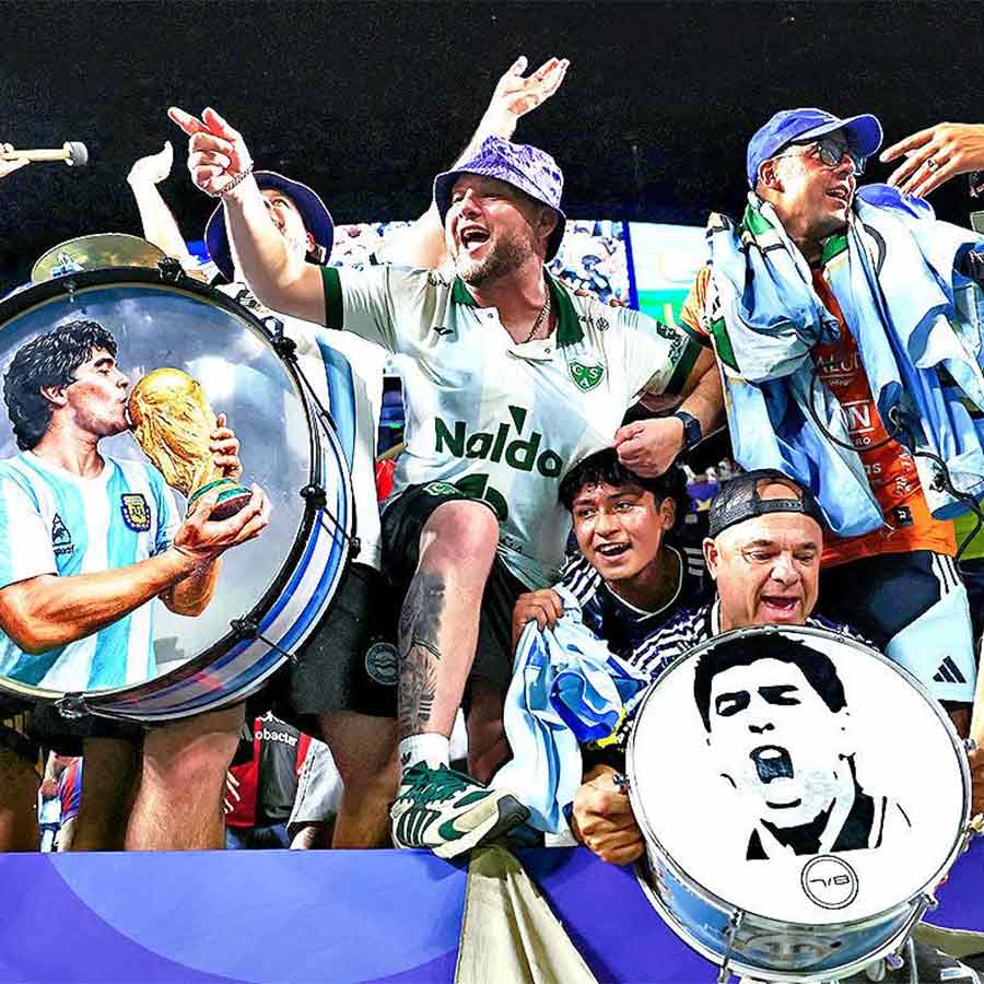 উৎসব: মেসিদের জয়ের পরে মারাদোনার ছবি আঁকা বাদ্যযন্ত্র নিয়ে স্টেডিয়ামে আর্জেন্টিনার সমর্থকেরা।