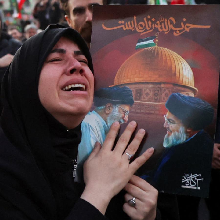 তেহরানের রাস্তায় খামেনেইয়ের ছবি হাতে কান্না এক ইরানি তরুণীর।