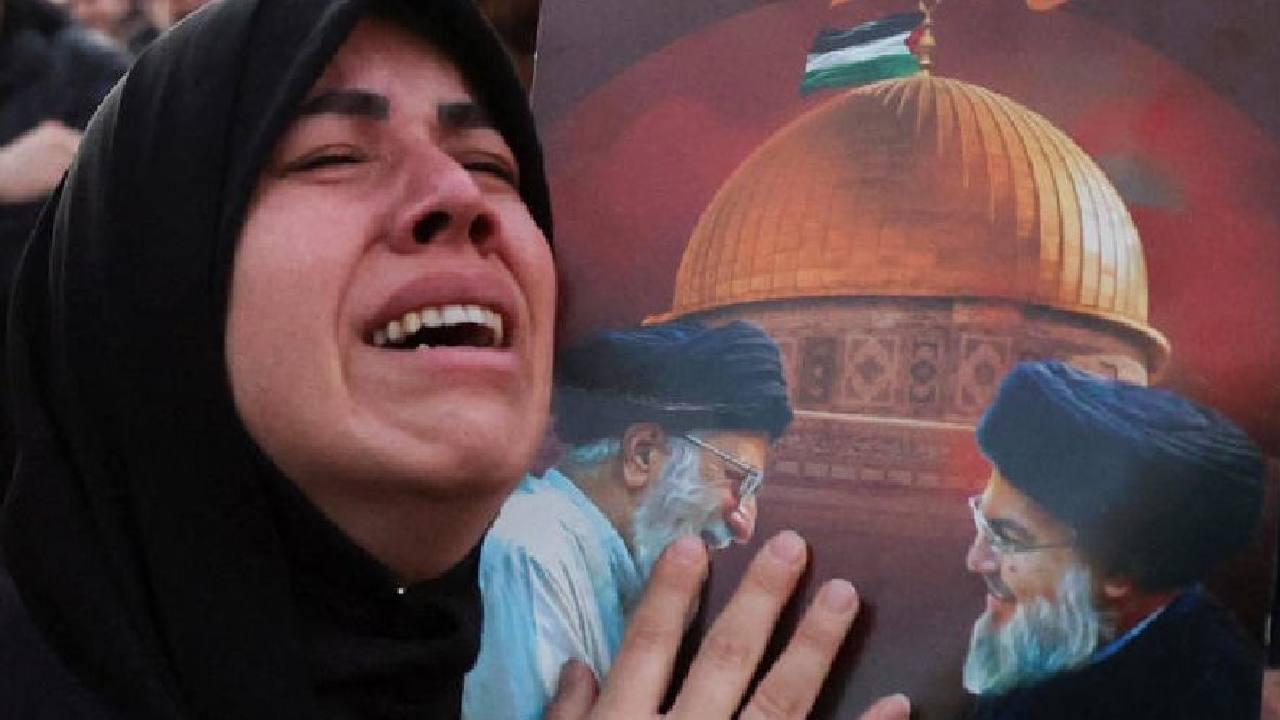 তেহরানের রাস্তায় খামেনেইয়ের ছবি হাতে কান্না এক ইরানি তরুণীর।
