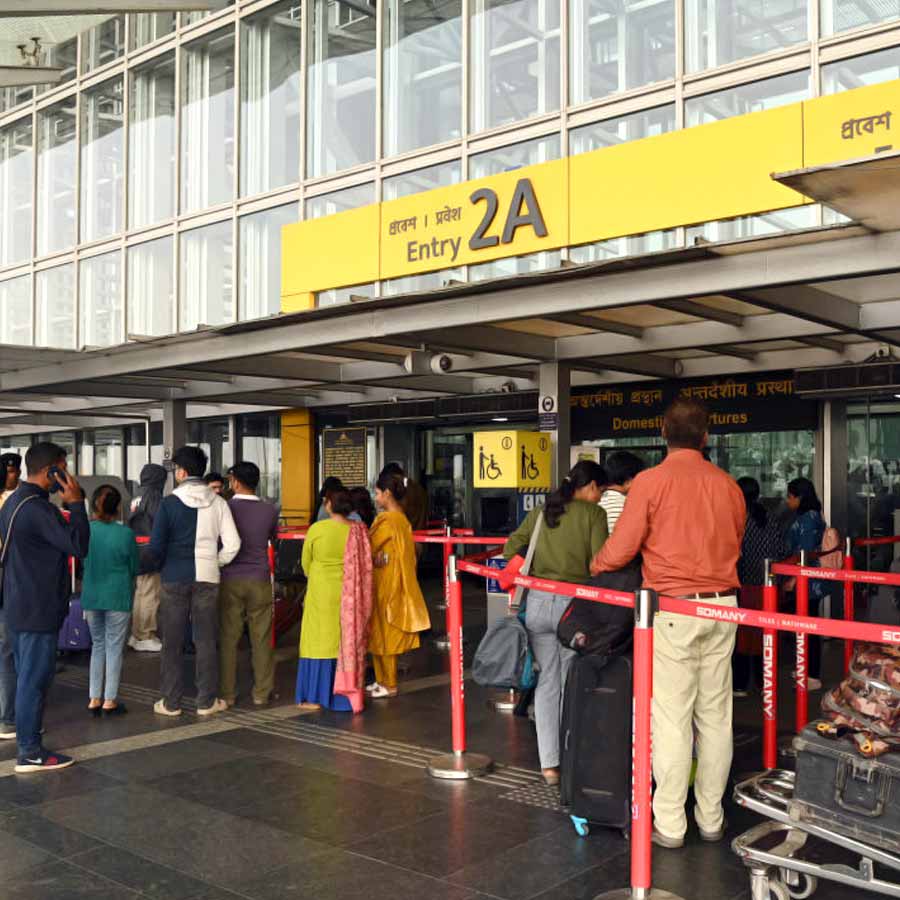 দমদম বিমানবন্দরের বাইরে যাত্রীরা।