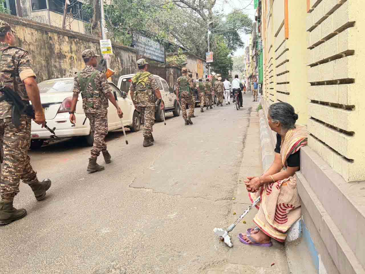 কেন্দ্রীয় বাহিনীর টহল দেখতে ব্যস্ত এক বাসিন্দা।
