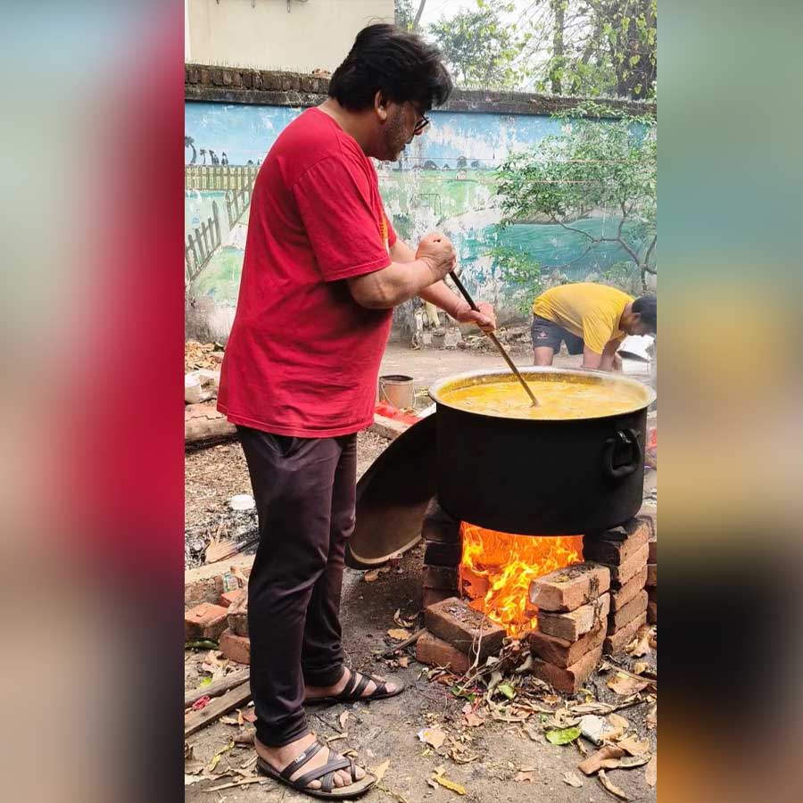 দমদমে একটি স্বেচ্ছাসেবী সংস্থার কমিউনিটি রান্নাঘরে অস্থায়ী উনুনে কাঠের জ্বালানি দিয়ে মিড-ডে মিলের রান্না।