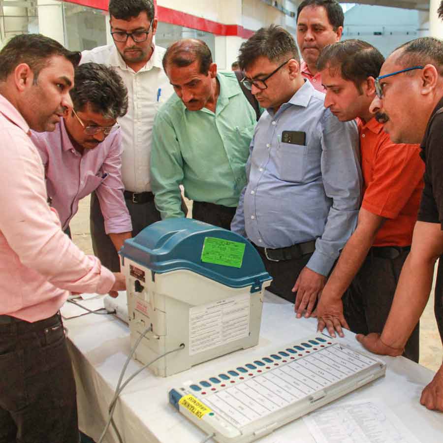 ইভিএম যন্ত্র খতিয়ে দেখছেন ভোটকর্মীরা।