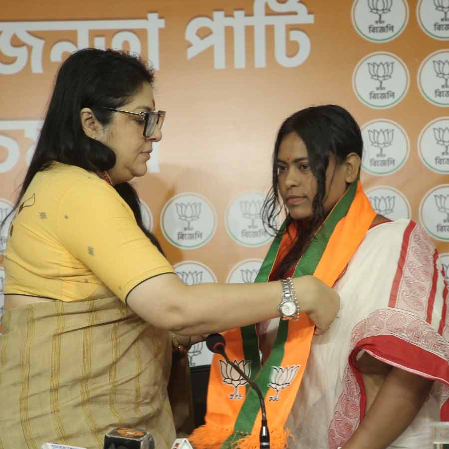 (বাঁ দিকে) টুম্পা কয়ালের গলায় দলের উত্তরীয় পরিয়ে দিচ্ছেন লকেট চট্টোপাধ্যায় (ডান দিকে)।