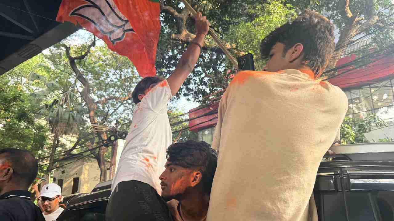 বিজেপি কর্মীরা গেরুয়া আবীর মেখে গাড়িতে।
