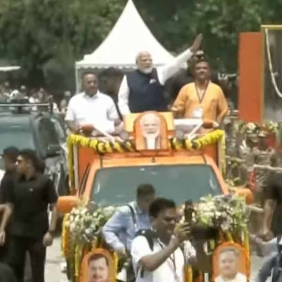 হুডখোলা গাড়ি থেকে হাত নাড়ছেন শমীক ভট্টাচার্য, নরেন্দ্র মোদী এবং শুভেন্দু অধিকারী।