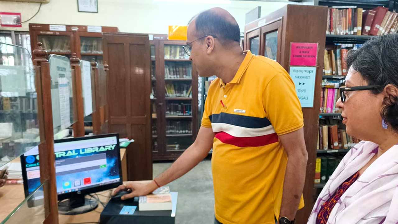 গ্রন্থাগার থেকে বই নিচ্ছেন এক শিক্ষক ।