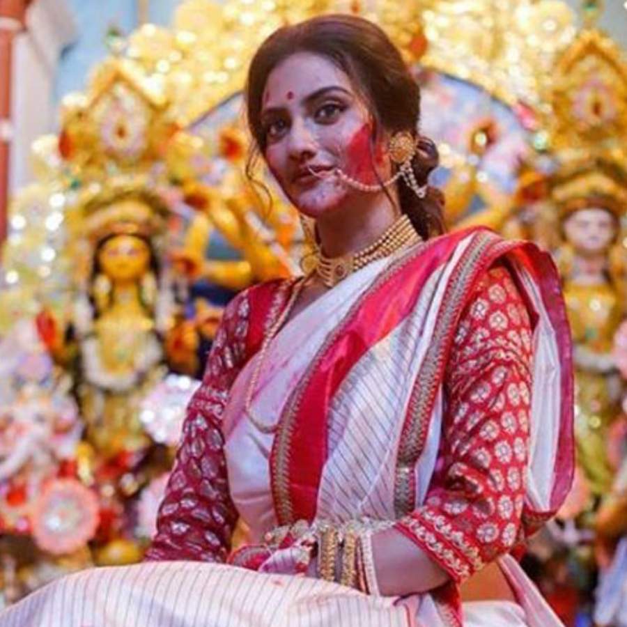 এ দিনও তার অন্যথা হল না। গত ২৩ অক্টোবর, পাইক বাড়ির বিজয়া দশমীর উদ্‌যাপনে একইভাবে নজর কাড়লেন তিনি। পরনে লাল পাড় সাদা শাড়ি। সিঁথিতে রাঙা সিঁদুর। 