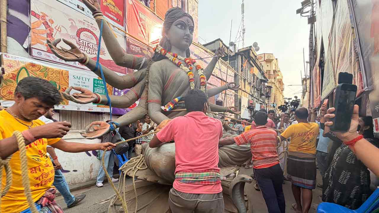 গলি থেকে বার করে নিয়ে যাওয়া হচ্ছে প্রতিমা।