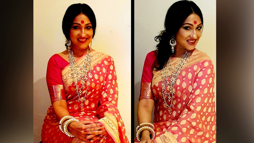 শাড়ির সাজে বিস্ময় এনেছেন  ঋতু। ভারী গয়না আর সাদা-গোলাপি অঞ্জলি শাড়ি। ব্লাউজহীন সাজে অনন্য ঋতুপর্ণা। খোঁপায় ফুলের মালা তৈরি করেছে উৎসবের আমেজ।