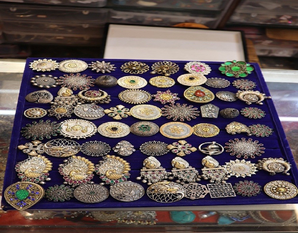 হাতের পরুন ওভারসাইজড আংটি। রঙিন পাথর বসানো বা শঙ্কর ধাতুর উপর নিখুঁত হাতের কাজের এই আংটি আপনার সাজে এনে দেবে অভিনবত্বের ছোঁয়া। এর বাজার মূল্য ১৫০ থেকে ৫০০ টাকার মধ্যে।