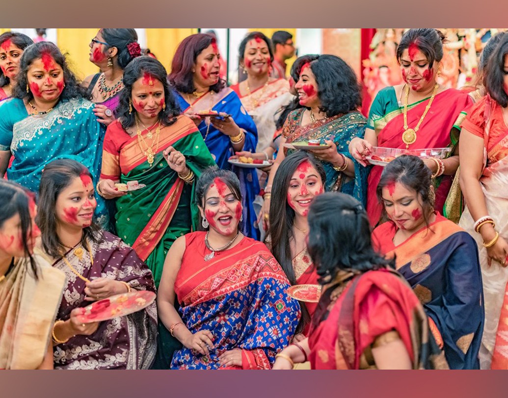 একে অপরকে সিঁদুর দিয়ে মিষ্টি খাইয়ে জানালেন বিজয়ার শুভেচ্ছা। কলকাতা থেকে বহু মাইল দূরে এ যেন এক টুকরো কলকাতা। সিঁদুর খেলার পর সকলে মেতে ওঠেন ছবি তোলায়।