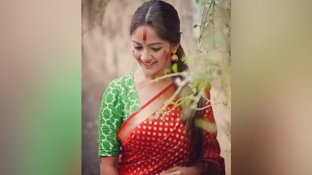 জরিপাড় বুটি দেওয়া লাল শাড়ি আর সবুজ ব্লাউজে টেলিপর্দার চেনা মুখ তৃণা সাহা যেন পলকে পাশের বাড়ির মেয়ে। দুষ্টুমিষ্টি টেলি-নায়িকার মুখে লেগে থাকা লাজুক হাসি যেন একরাশ স্নিগ্ধতা ছড়িয়ে দিল ইনস্টাগ্রামে।