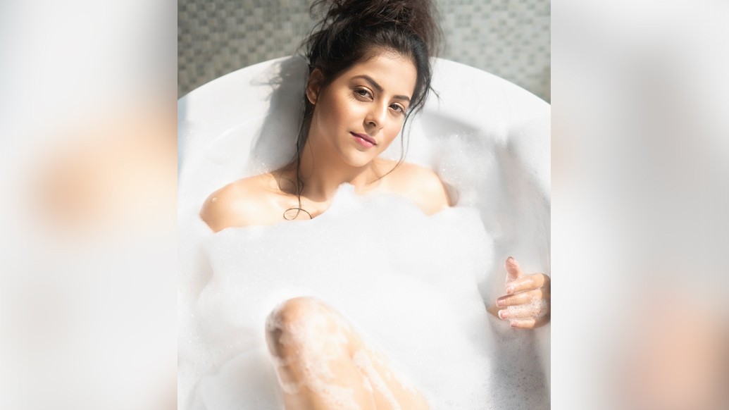 দুধ সাদা ফেনিল স্বপ্ন মাখা সাবানের ওম। তার মধ্যে থেকেই আবরণহীন শরীরের উঁকিঝুঁকি। মেকআপের প্রলেপহীন, স্বাভাবিক সৌন্দর্যে আকর্ষণীয়। মাথার উপরে  চুড়ো করে তোলা একগুচ্ছ চুলের ক্যাজুয়াল হাতখোঁপা।