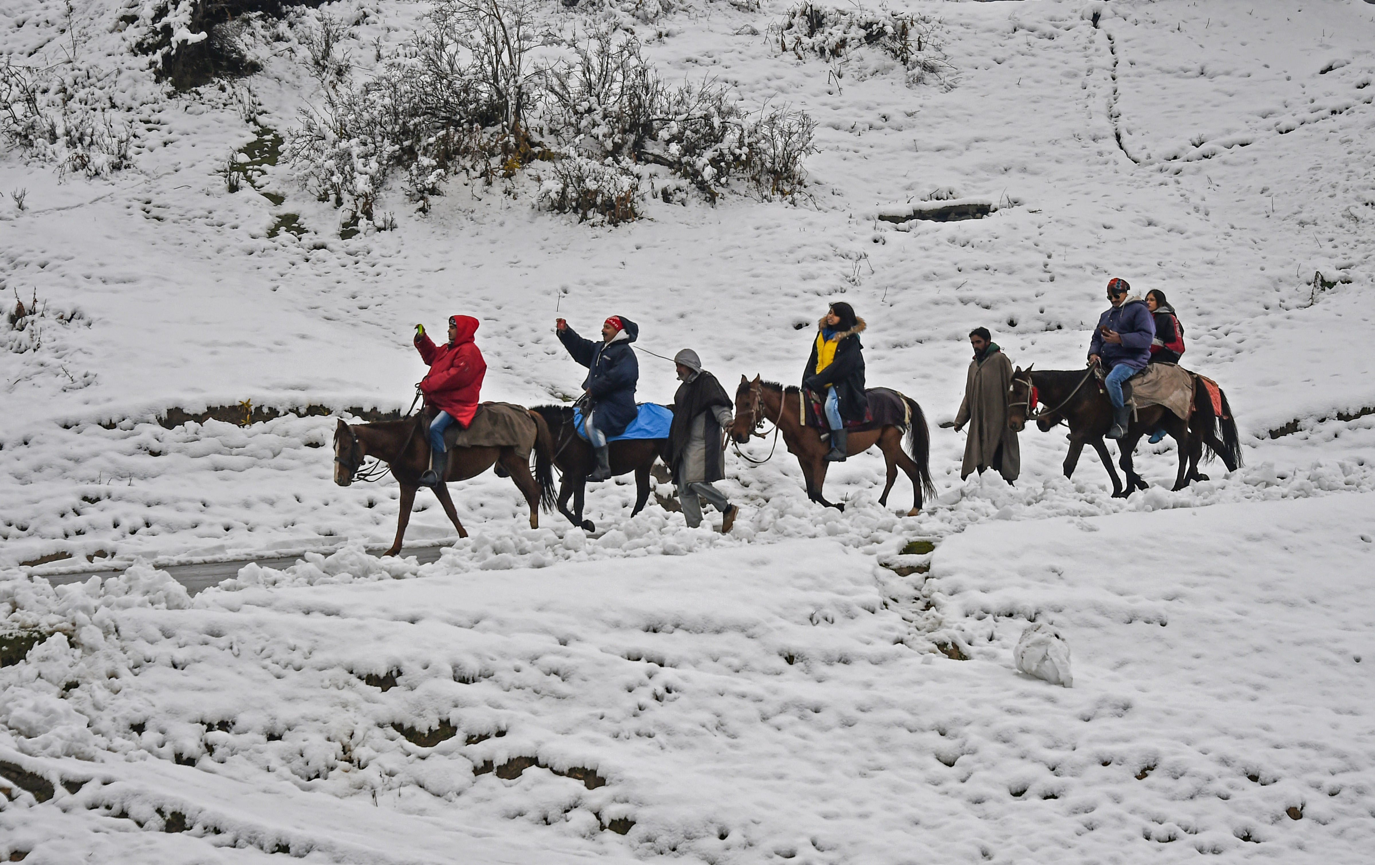 Tourists on a pony ride after the season's first snowfal in Gulmarg.