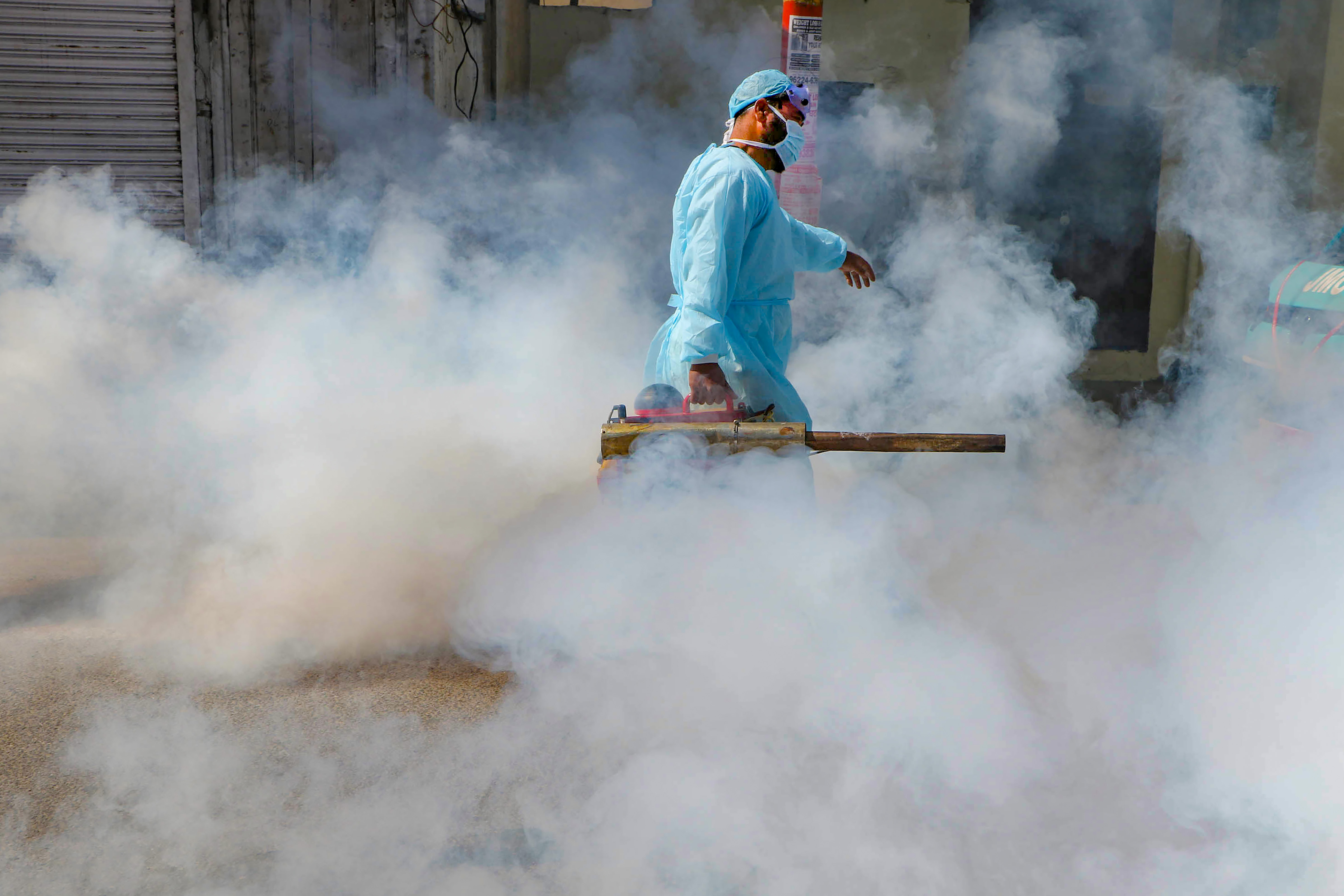 A Jammu Muncipal Corporation worker spray disinfectant on a street during Janta curfew in the wake of deadly coronavirus, in Jammu, Sunday, March 22, 2020.