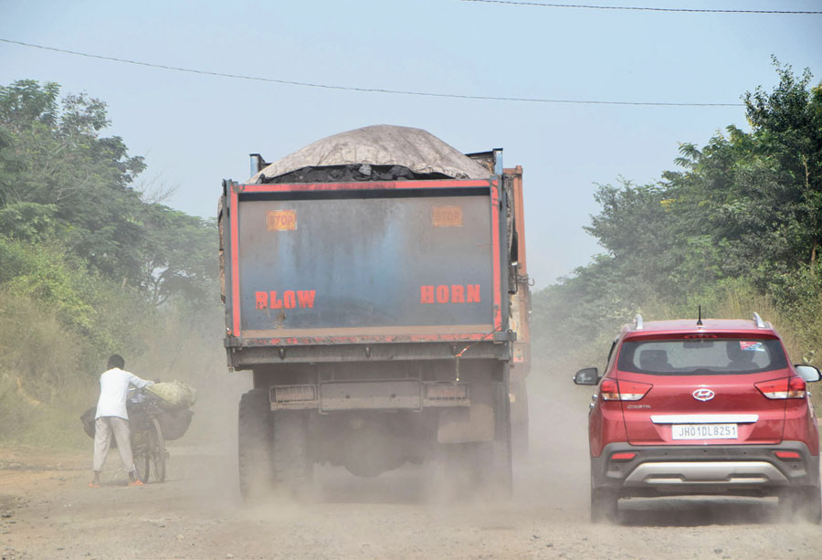 A coal-loaded truck releases smoke and dust in Dhanbad on Thursday. 