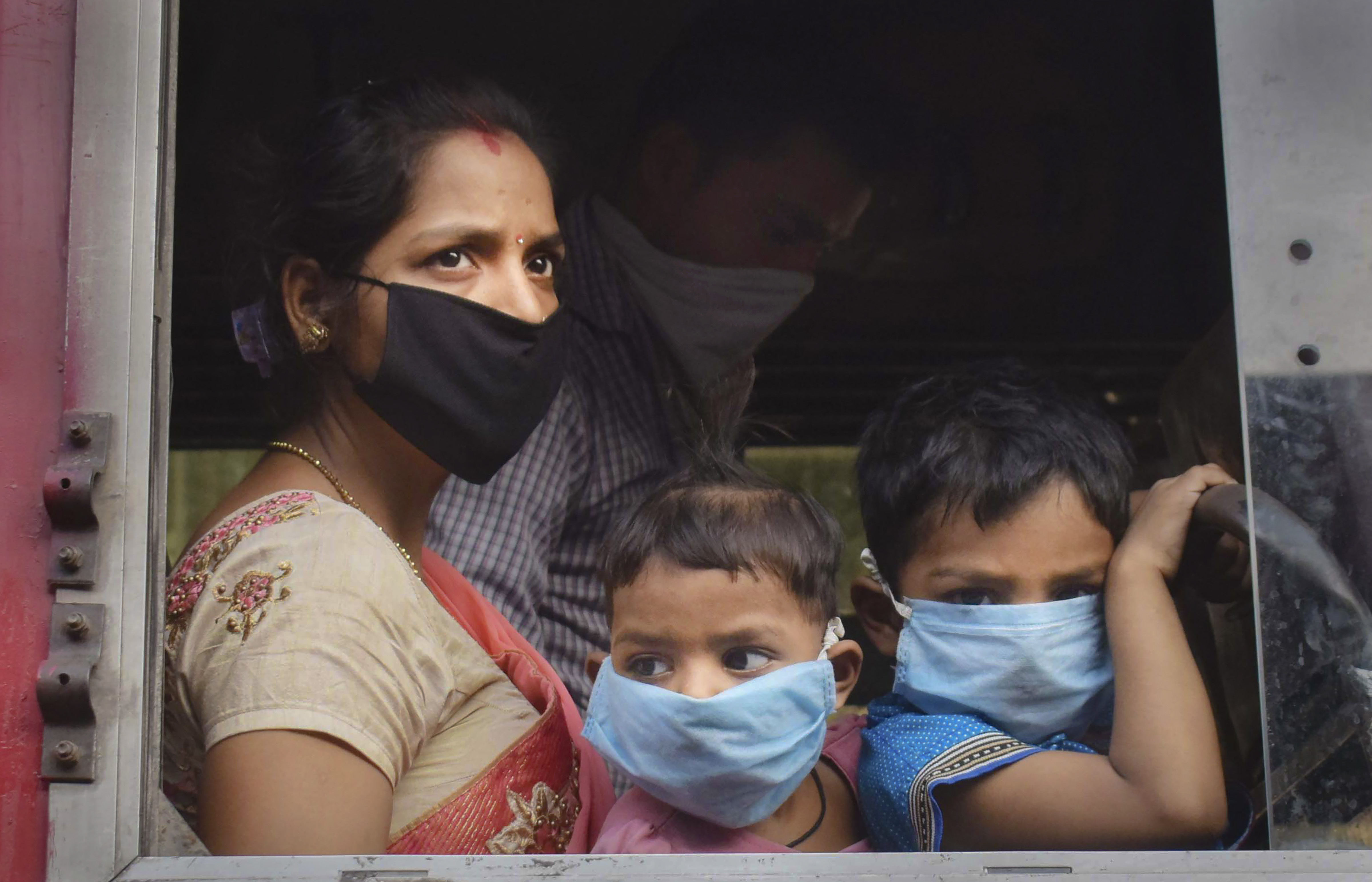 Migrants travelling from Surat via a special train board a bus to reach their native places, during the ongoing Covid-19 nationwide lockdown, in Prayagraj, Monday, May 18, 2020.