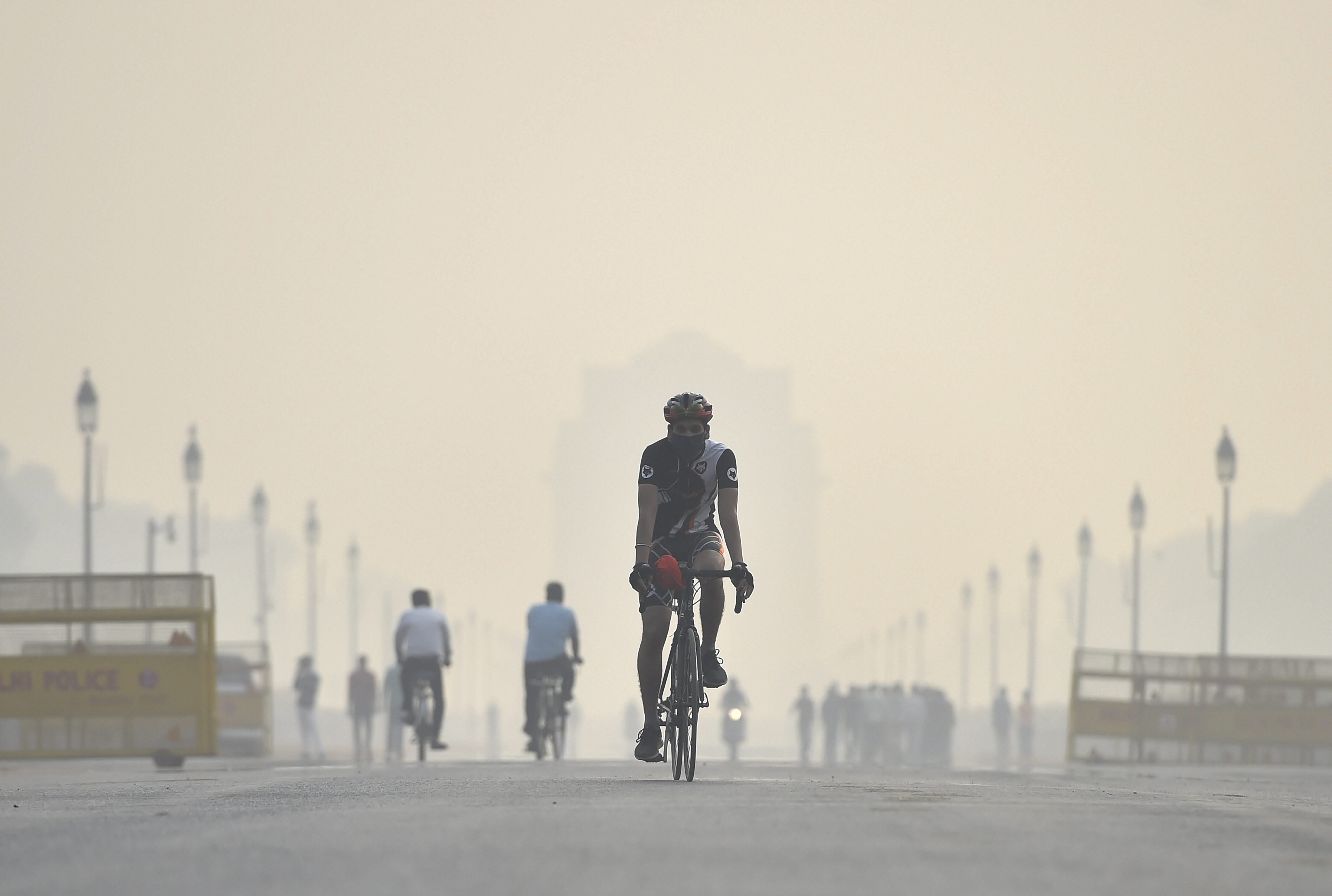 A mask wearing cyclist near India Gate. 