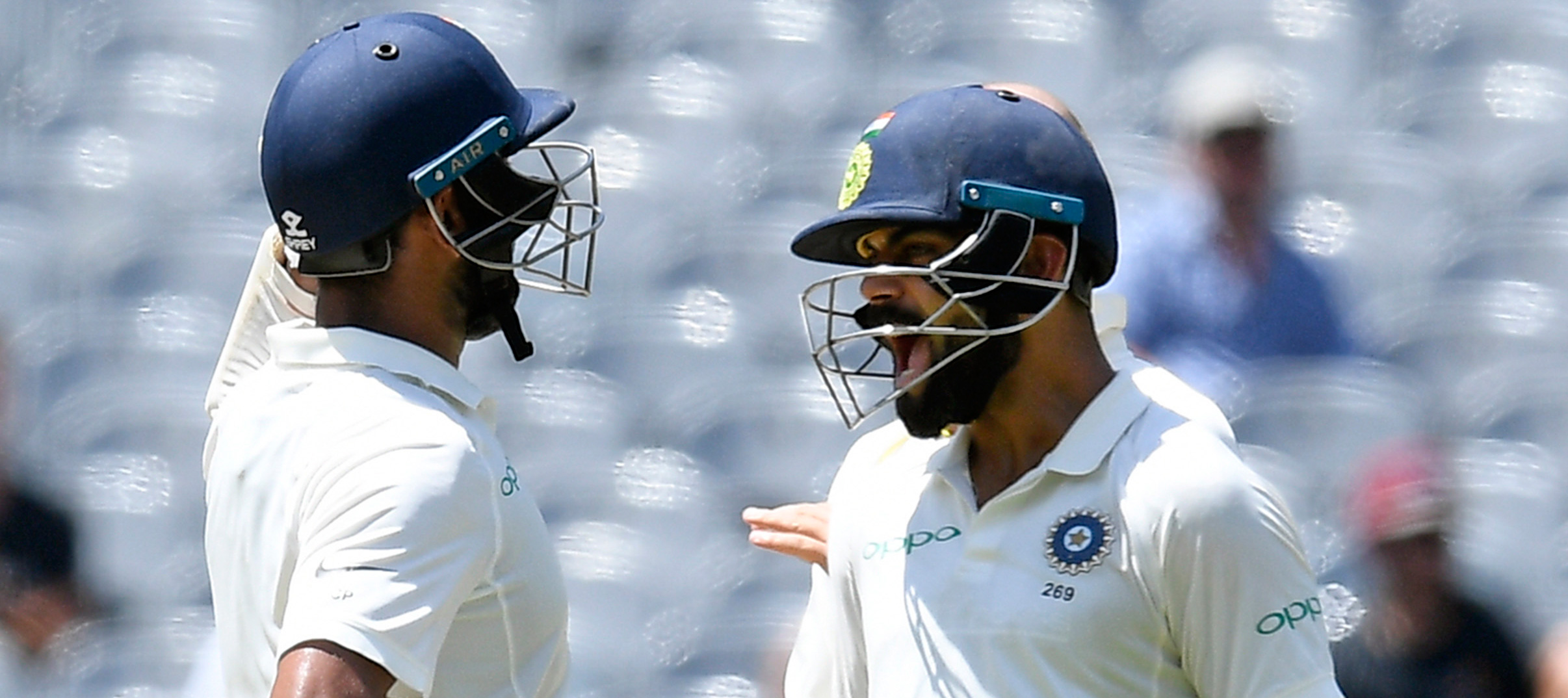 India's Virat Kohli, right, reacts after team mate Cheteshwar Pujara, left scores a century during play on day two of the third cricket test between India and Australia in Melbourne, Australia on Thursday, December 27, 2018.