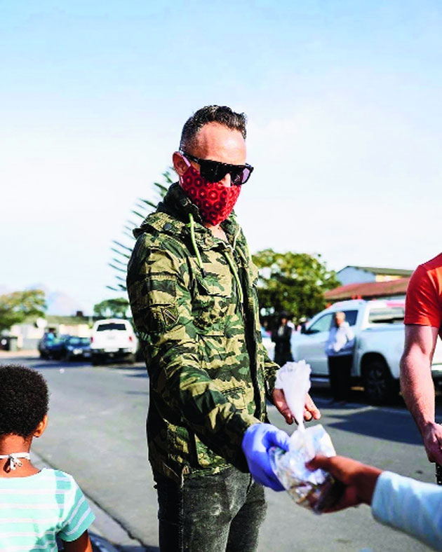 Former South Africa cricket captain Faf du Plessis distributes food in Cape Town.
