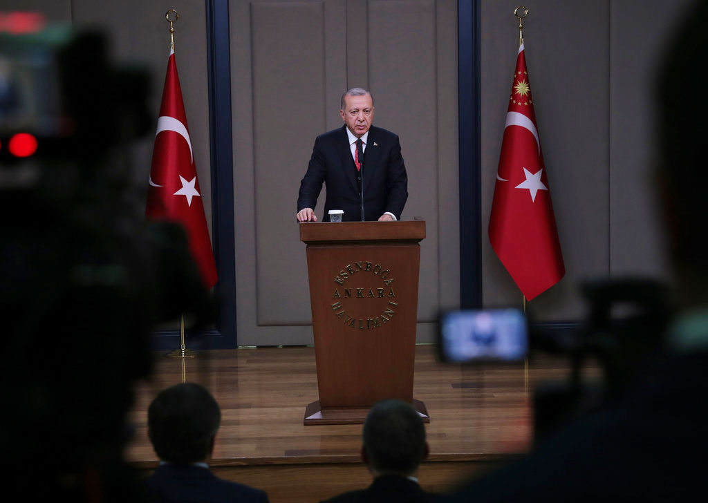 Turkey's President Recep Tayyip Erdogan talks to members of the media