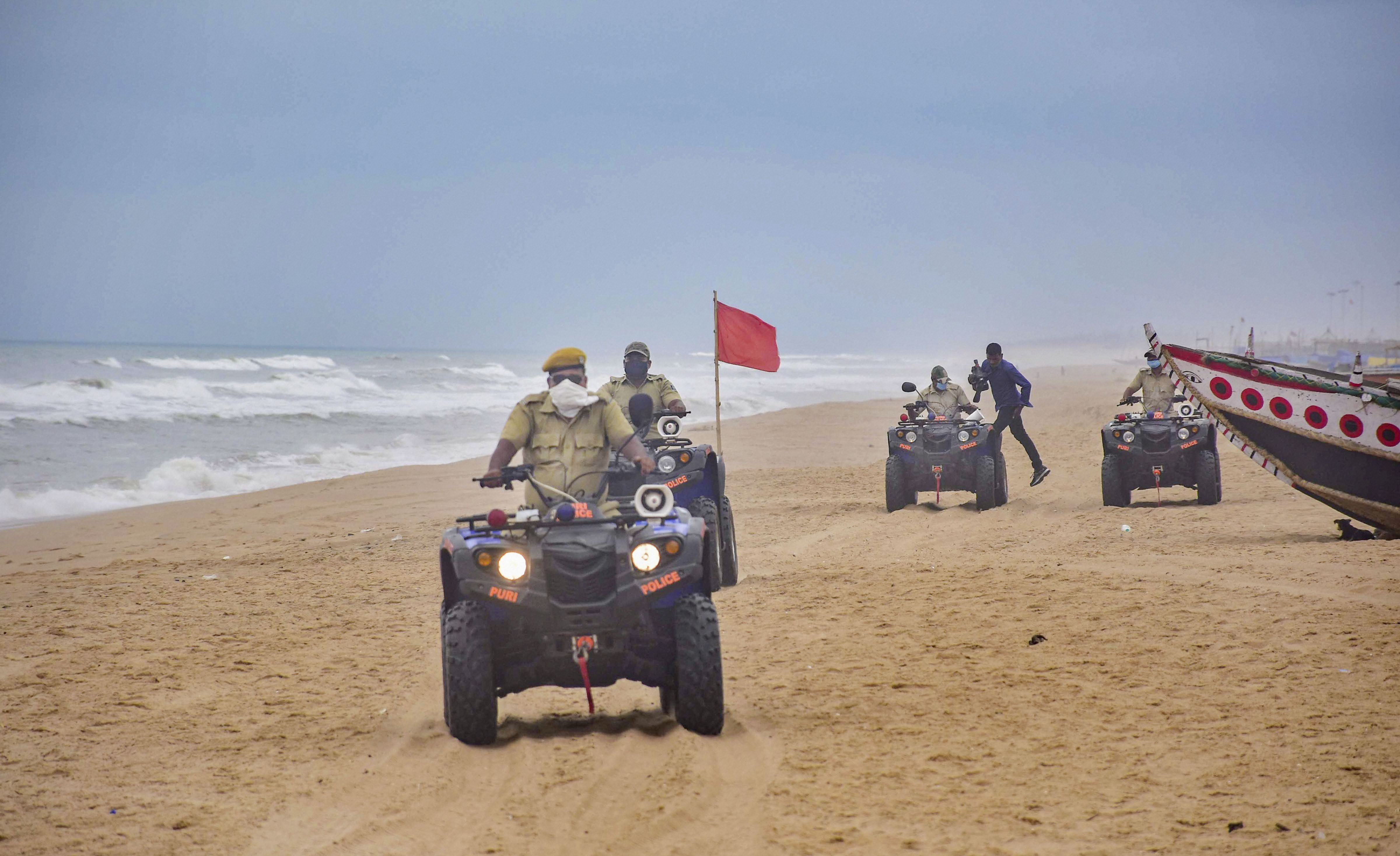 Marine police personnel patrol Puri beach to prevent tourists and fishermen from venturing into the sea due to Cyclone Amphan, in Puri, Sunday, May 17, 2020. 