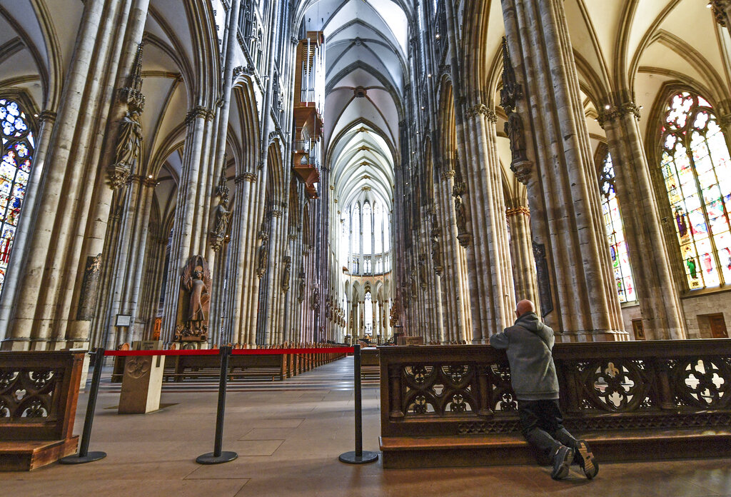 A man prays in the empty world famous Cologne Cathedral in Cologne, Germany, on Sunday, March 15, 2020