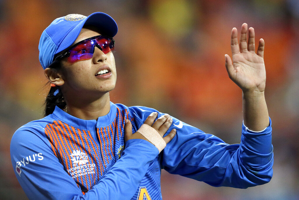 Smriti Mandhana leaves the field clutching her left shoulder after crashing into the signage while fielding against Australia in the Women's T20 Cricket World Cup in Sydney, on Friday