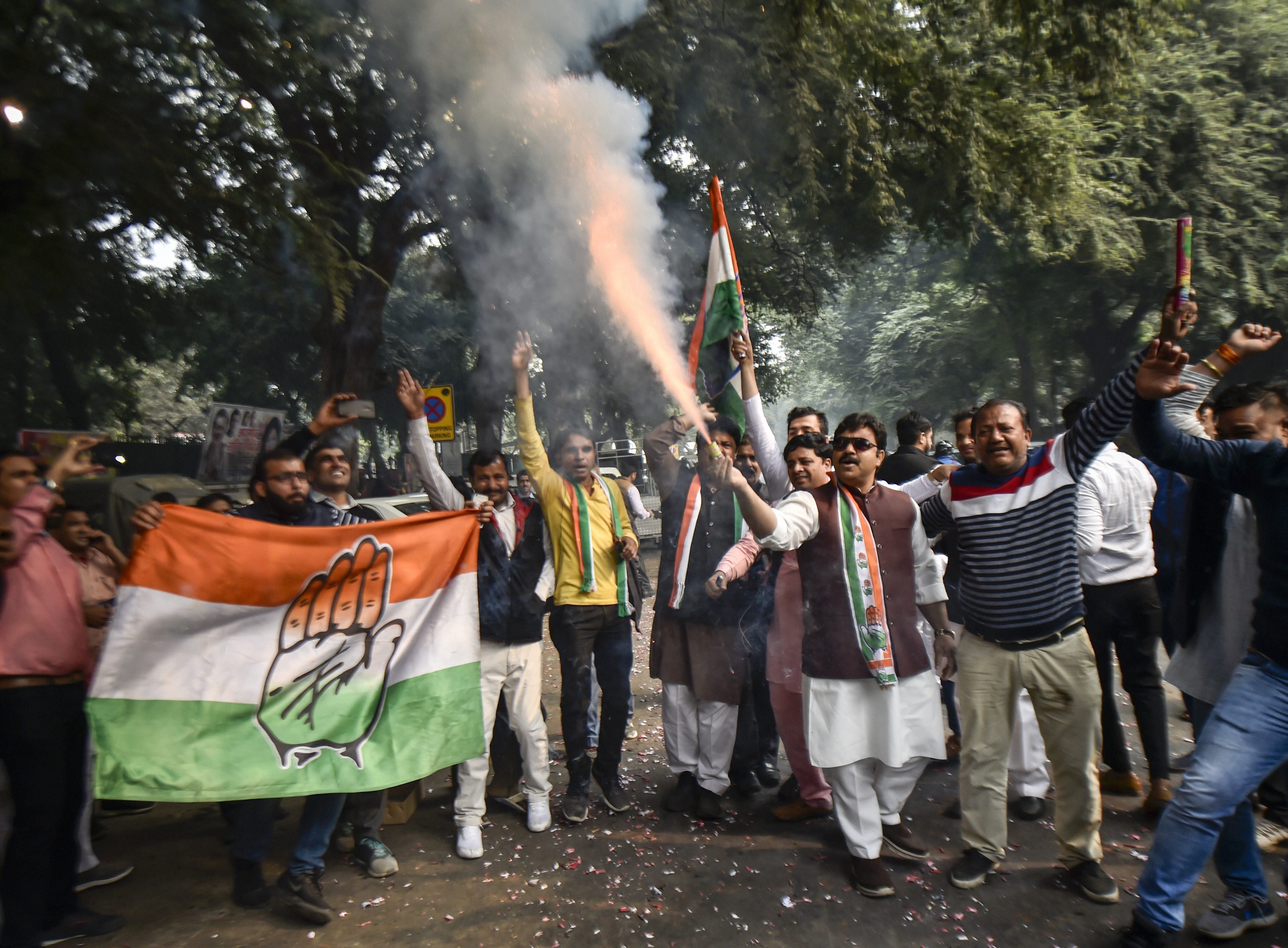 Congress workers celebrate as initial trends show the party leading in Assembly elections at the Congress headquarters in New Delhi on Tuesday. 