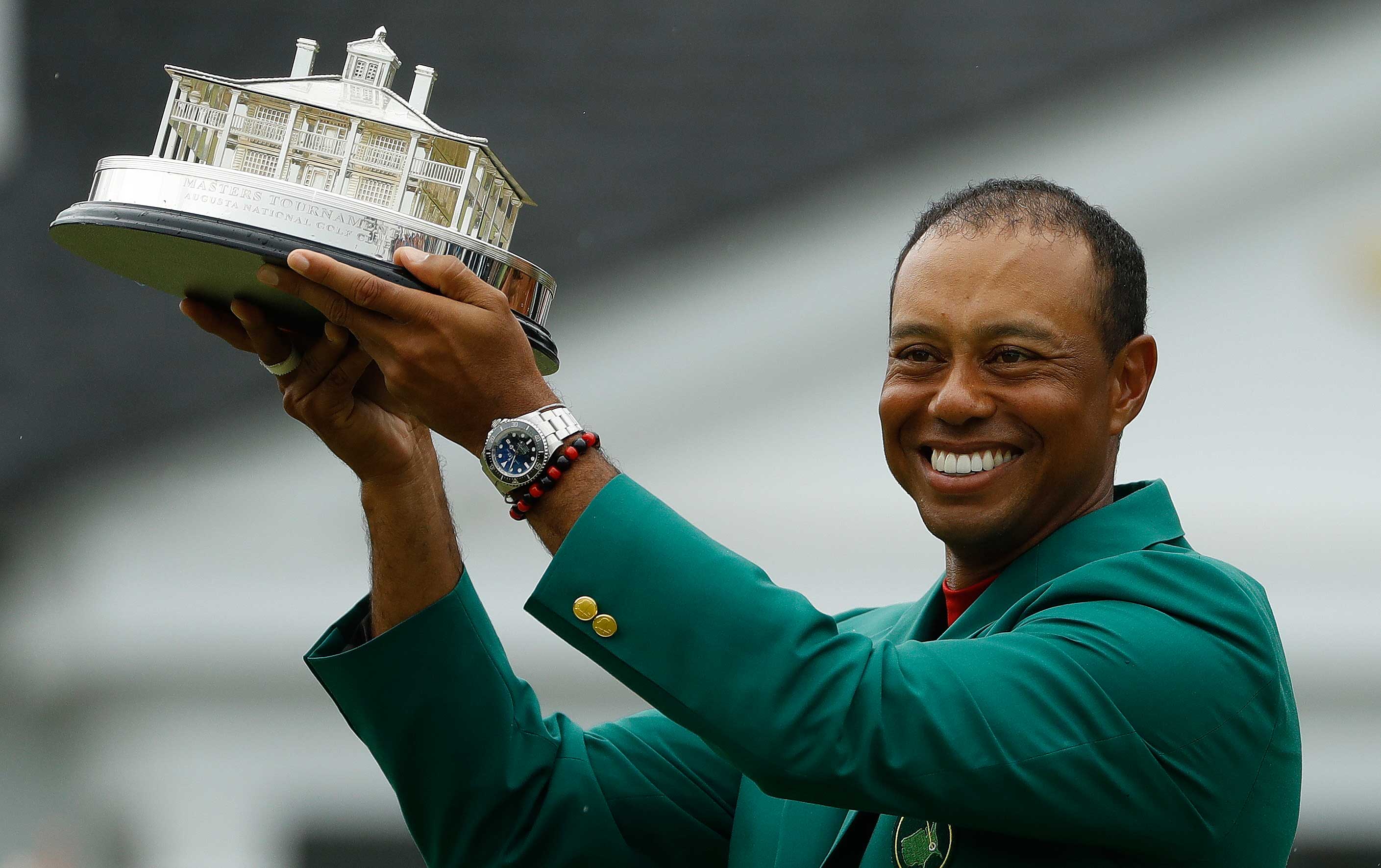Tiger Woods in the Green Jacket and with the Masters Trophy in Augusta on Sunday. 