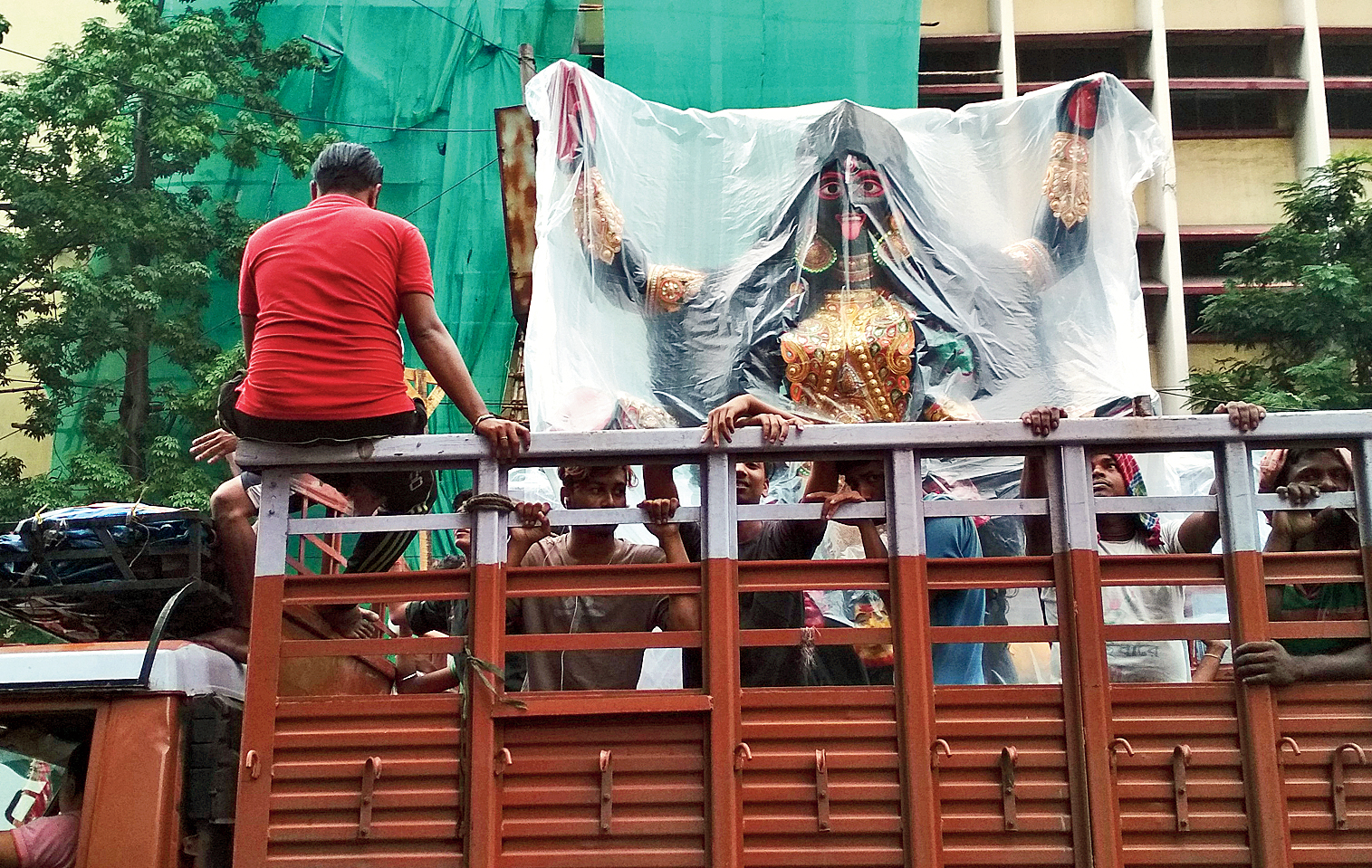 A truck carries an Kali idol wrapped in a plastic sheet through Central Avenue