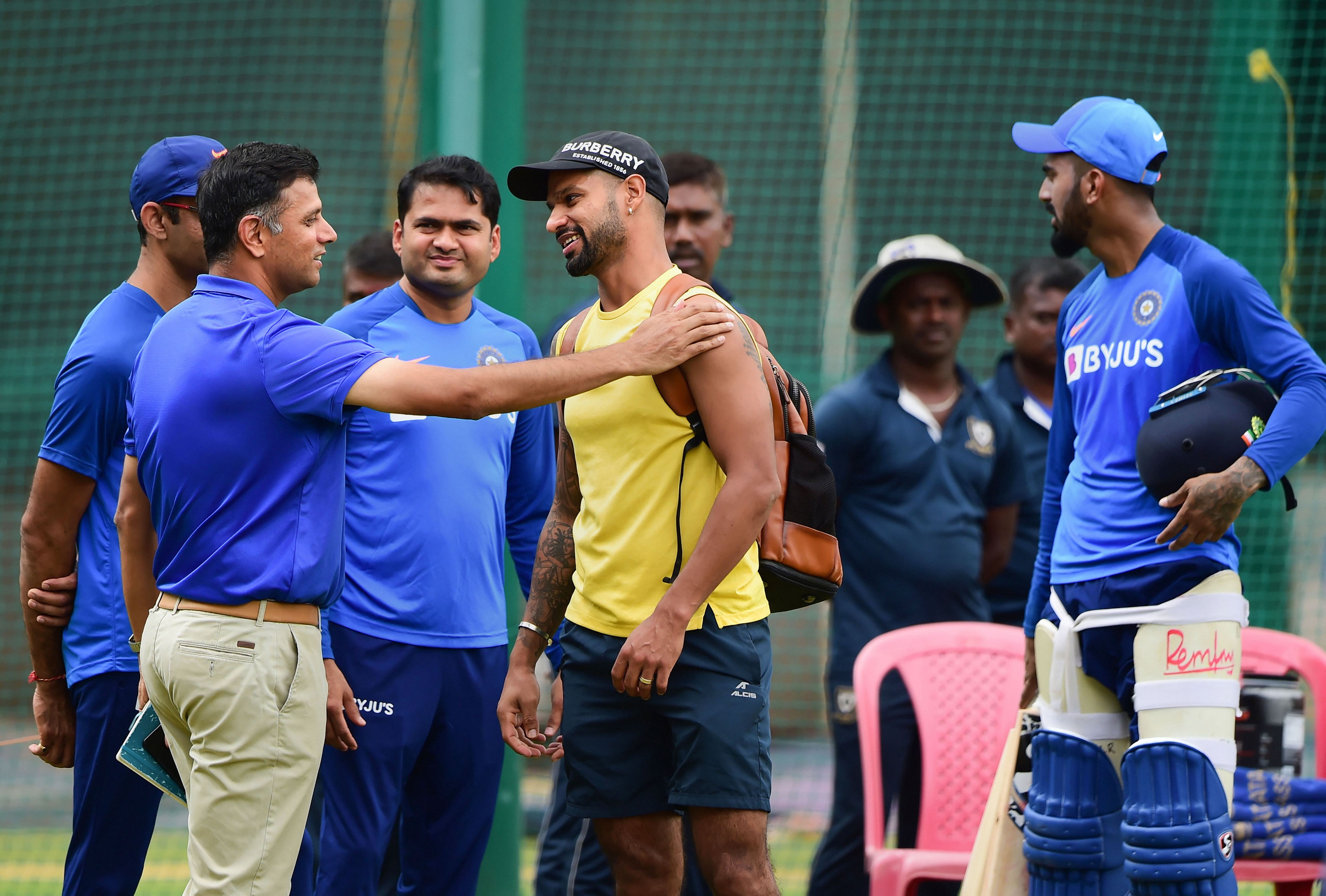 National Cricket Academy chairman Rahul Dravid interacts with cricketer Shikhar Dhawana during a practice session ahead of the third T20 match against South Africa at Chinnaswamy Stadium, in Bengaluru, Friday, September 20, 2019.