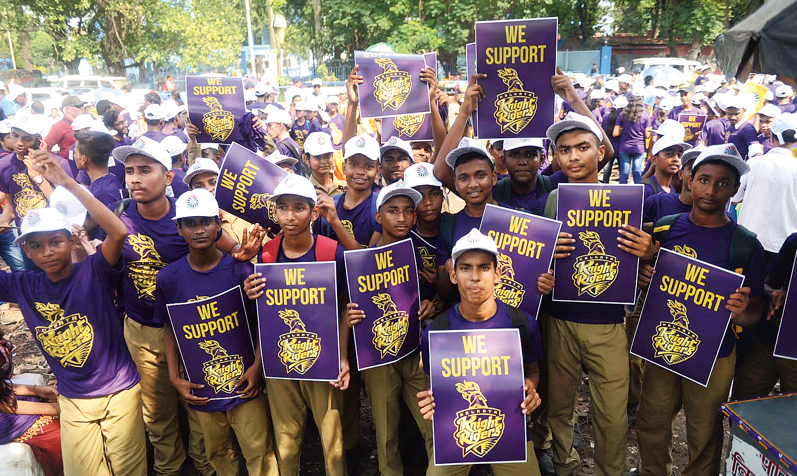 The children in purple jerseys armed with We Support KKR placards. 
