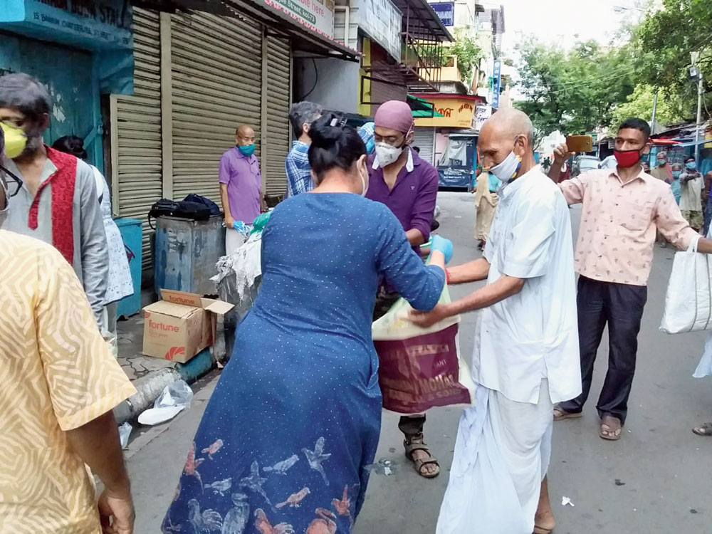 Present and former students of Presidency University distribute essentials in the College Street area on Sunday
