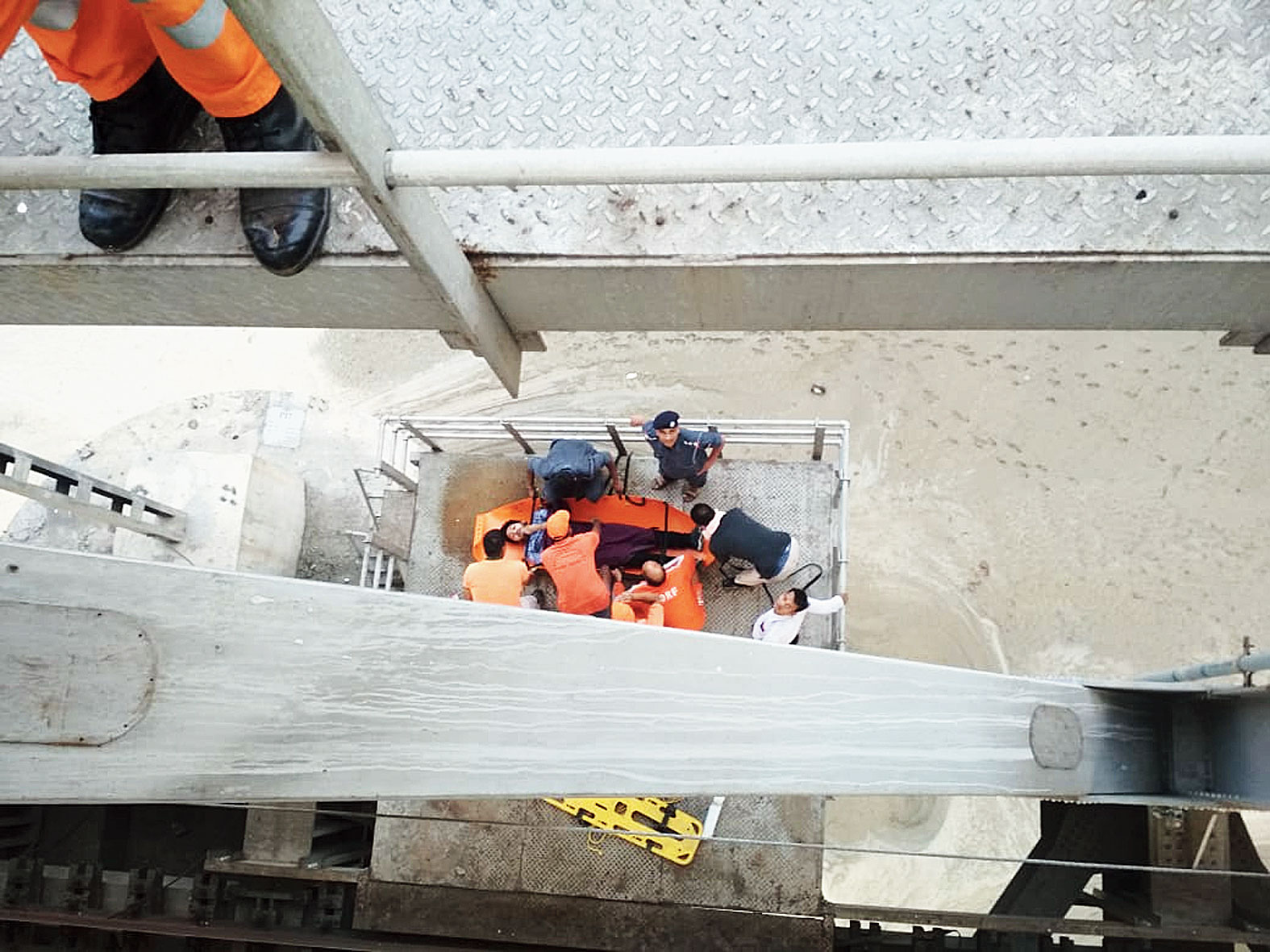After extrication, the youth is lowered to an observation deck and immobilised to save him from further injuries. He is then hoisted to the railway level or deck of the bridge
