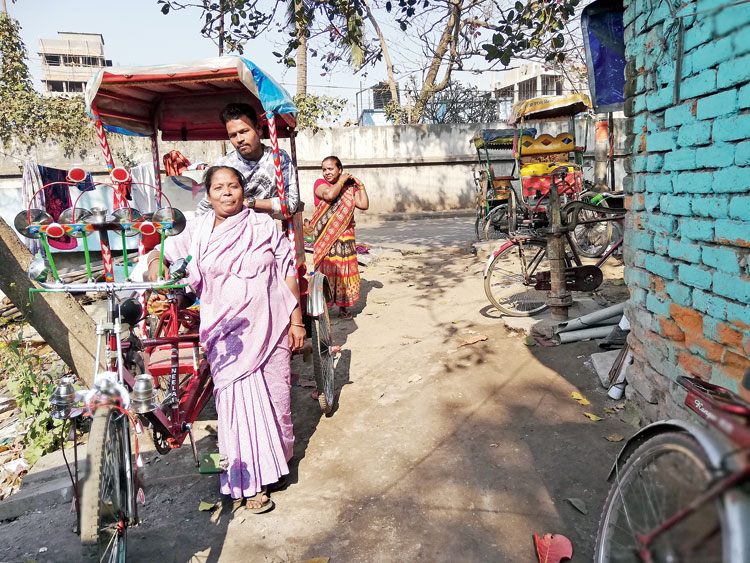 Ajmeri Khatun with her son and some of the rickshaws she has acquired over the years