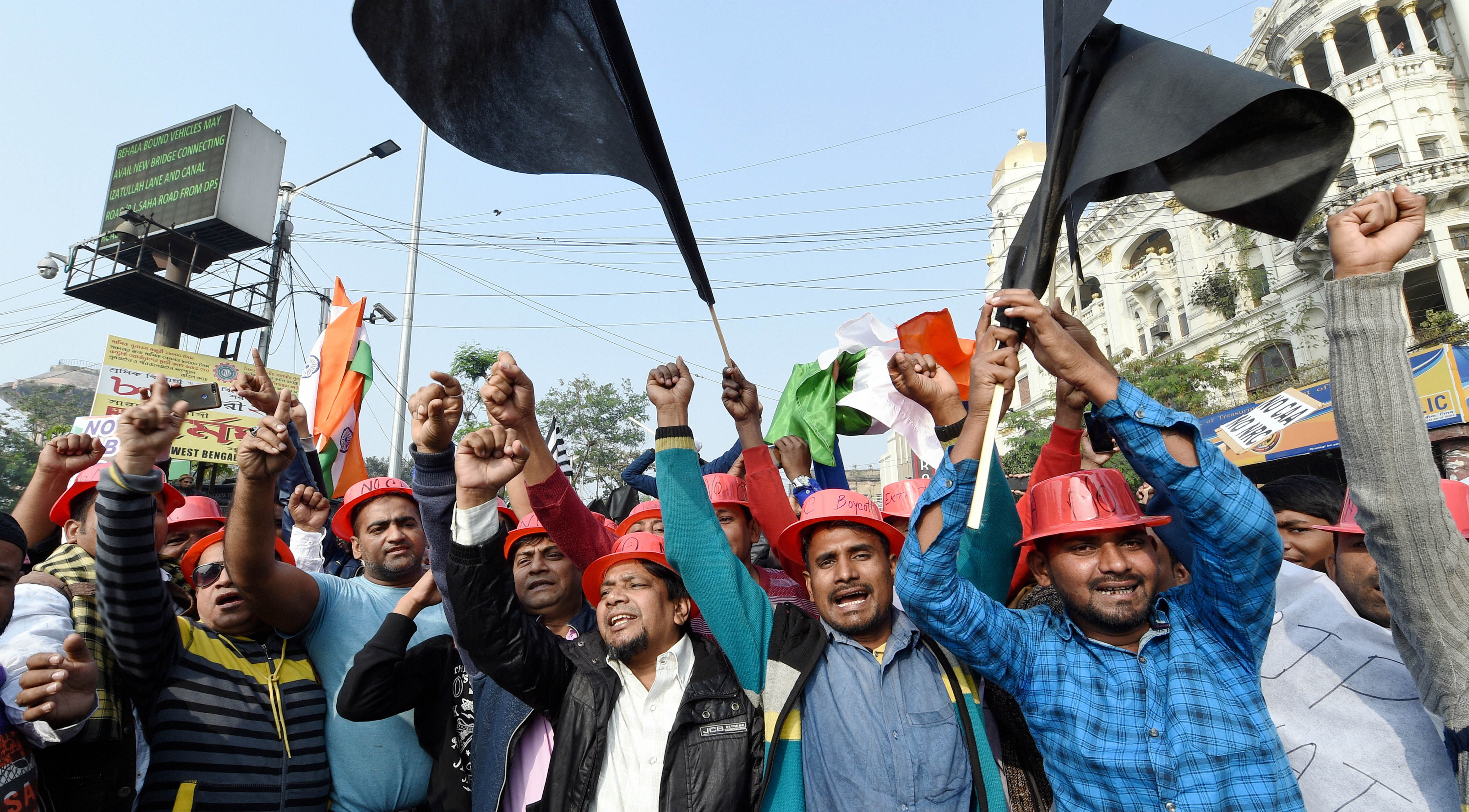 Protestors hold placards and raise slogans during a demonstration against the Citizenship Amendment Act (CAA) and NRC, in Kolkata, on December 22, 2019.