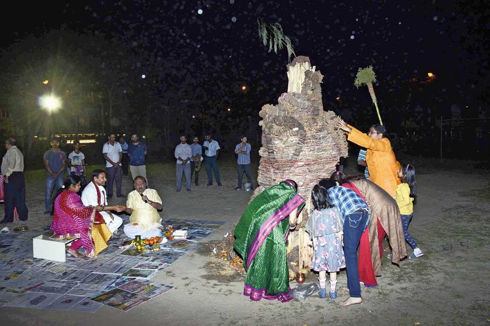 Devotees pray before the Holika Dahan pyre in CB Block