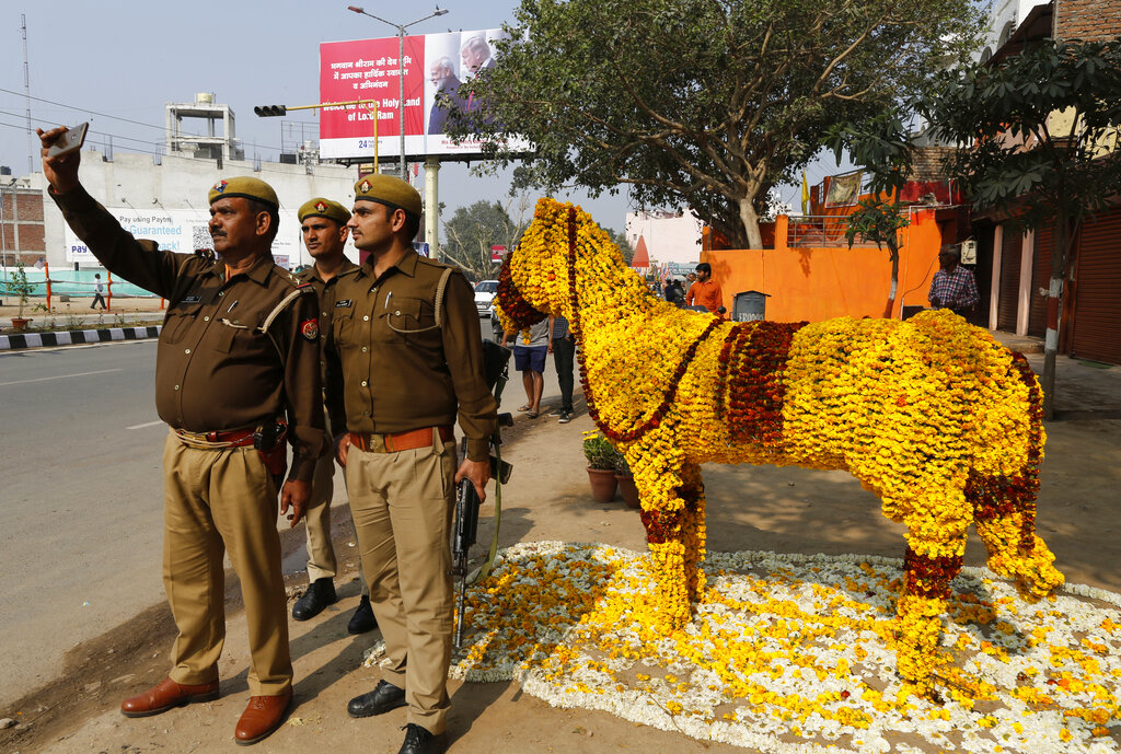 Policemen take a selfie on a street decorated with floral arrangements in Agra, on Monday