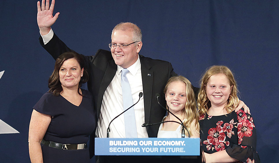 Australian Prime Minister Scott Morrison, with his wife Jenny (left) and daughters Lily and Abbey, waves to supporters during a victory rally in Sydney on Saturday. 
