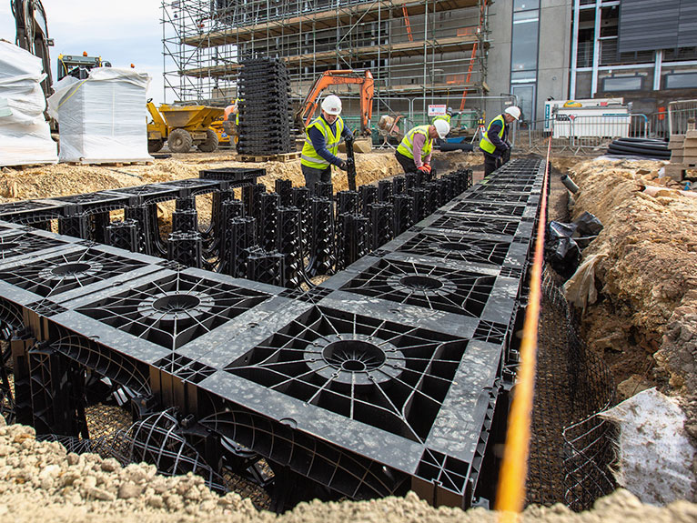 Silva cells being installed under a pavement to facilitate planting of trees while protecting service lines